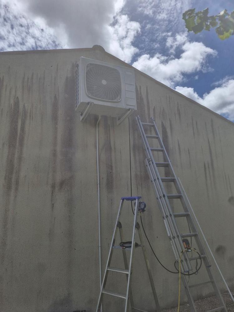 Pose d'une unité extérieure de climatisation réversible en façade par ABR Électricité