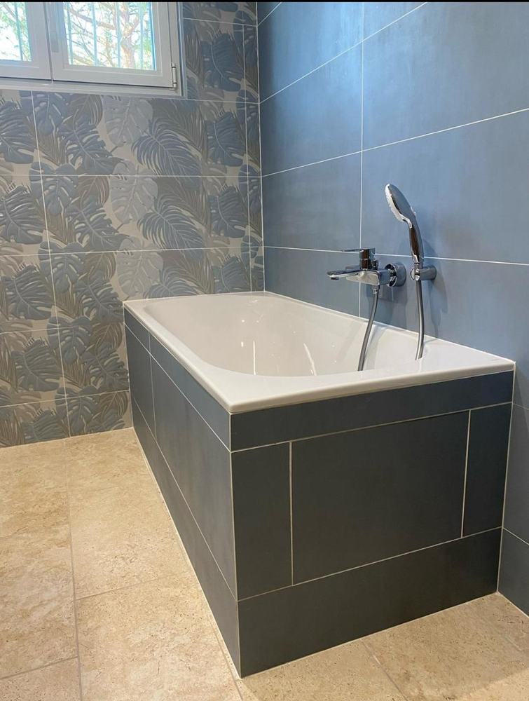 Rénovation de salle de bain à Tonnay-Charente, baignoire et faïence bleue posées par ABR Plomberie